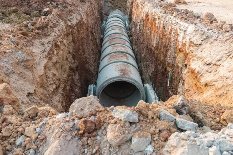 Sewer pipe being installed in an excavated trench